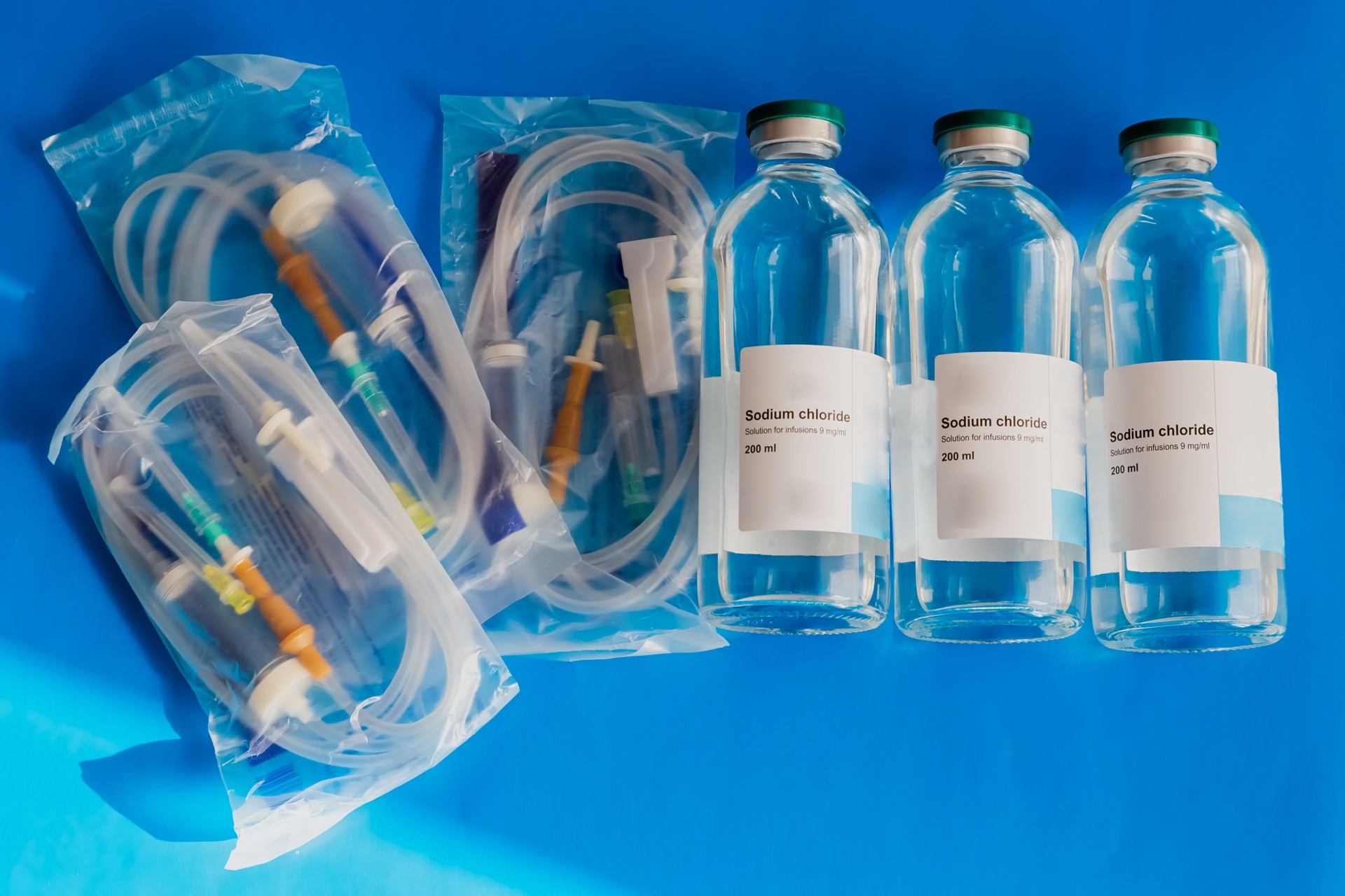A medical IV drip with saline solution in a glass bottle. A symbol of recovery, intensive care, and the importance of hydration therapy.